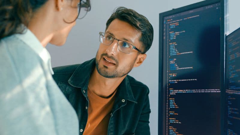 Closeup Of Software Engineering Team Engaged In Problem Solving And Code Analysis