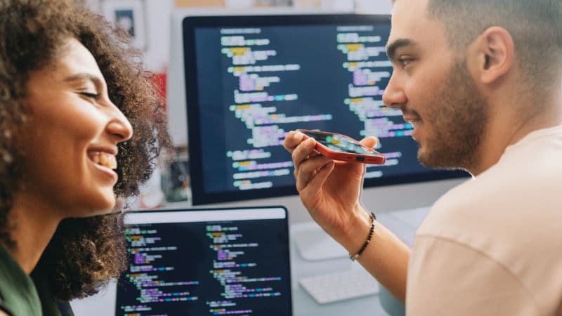 Two Young Software Developers Collaborating And Discussing Ideas While Working Together